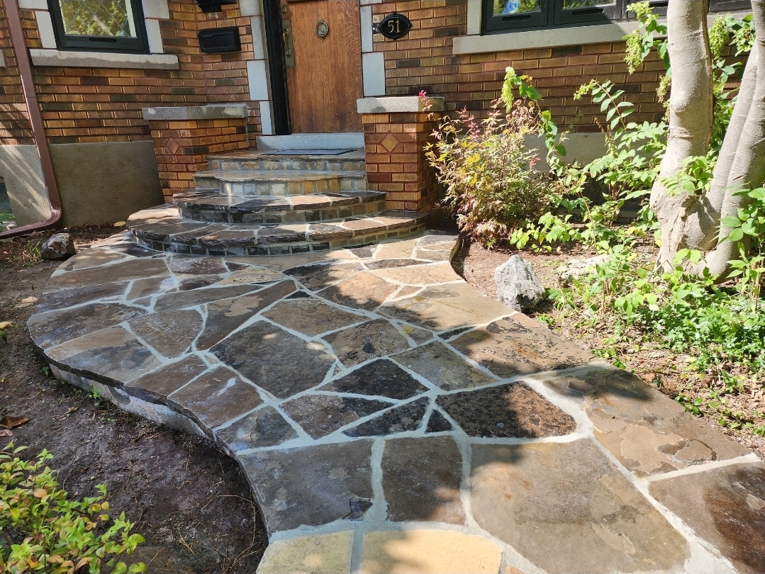 Finished natural-stone walkway and curved front steps by Robust Masonry